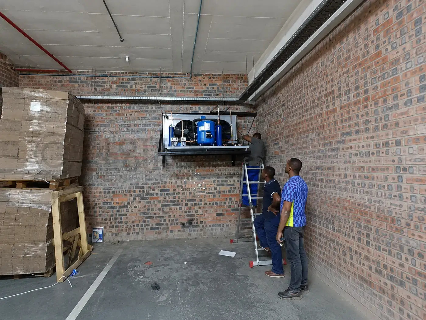 Technicians installing the Popco Ice Cream walk in freezer condensing unit in Salt River