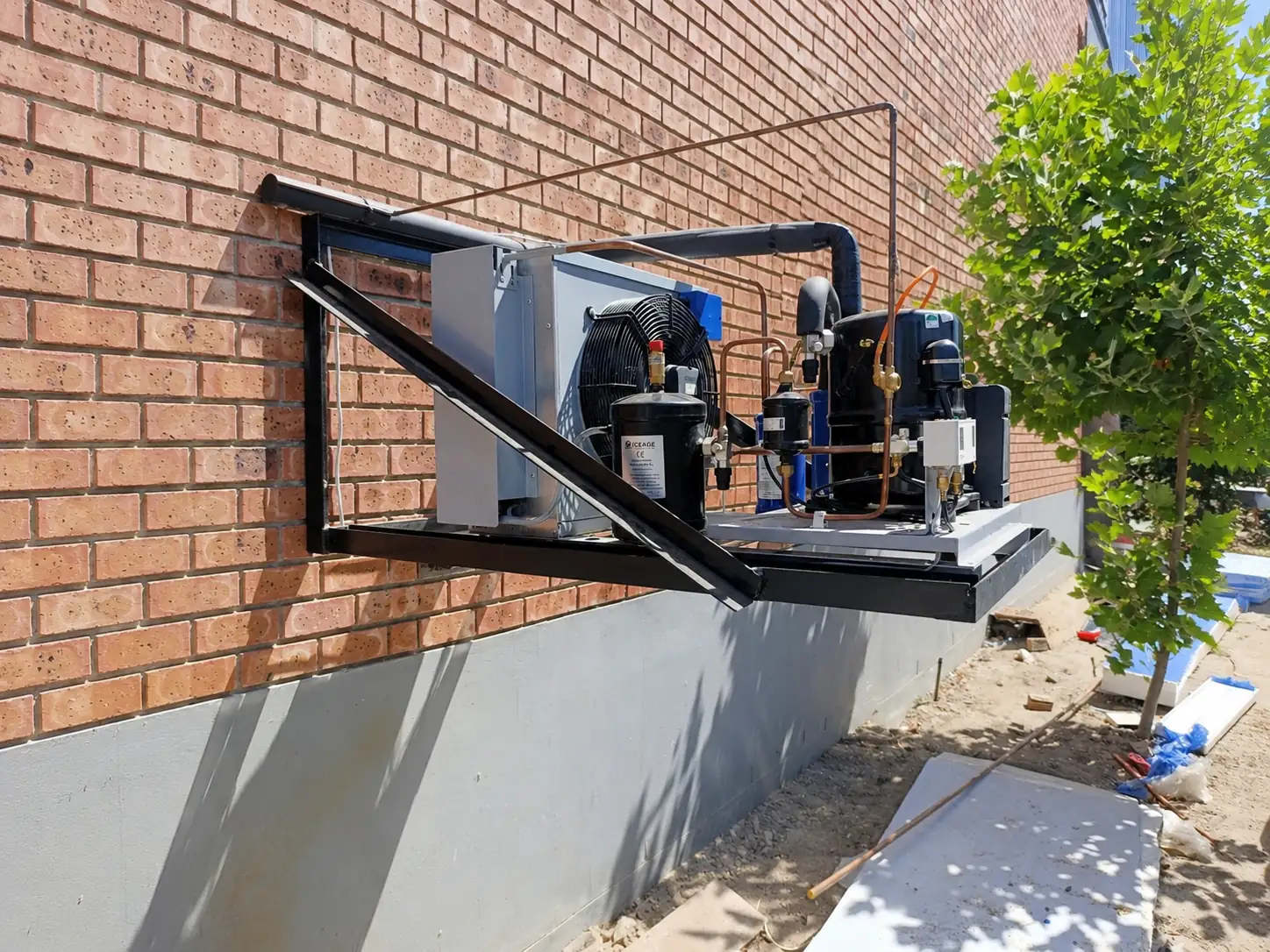 Cold room condensing unit mounted on an exterior brick wall