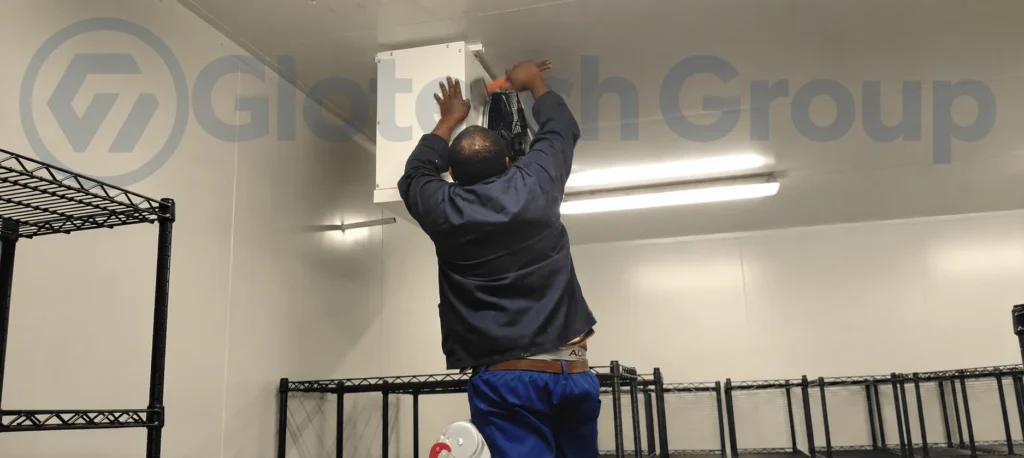 Technician completing an evaporator installation inside a commercial cold room