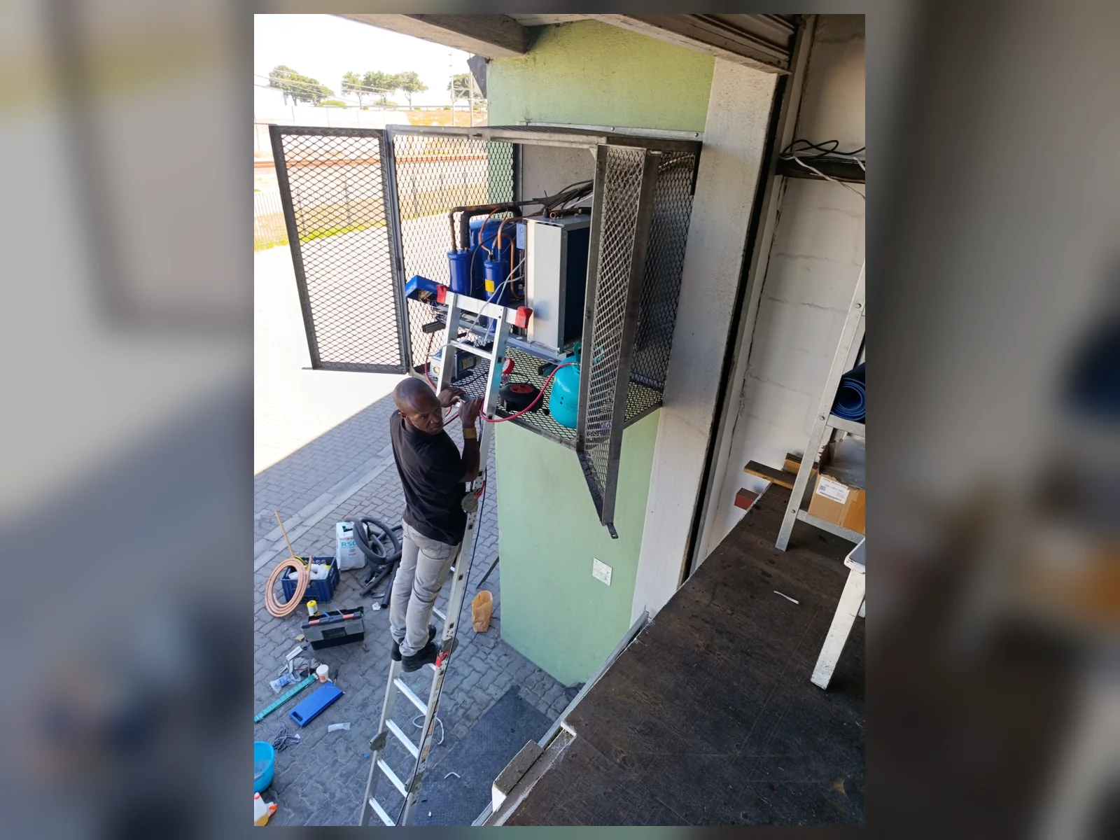 Refrigeration technician installing a commercial condensing unit