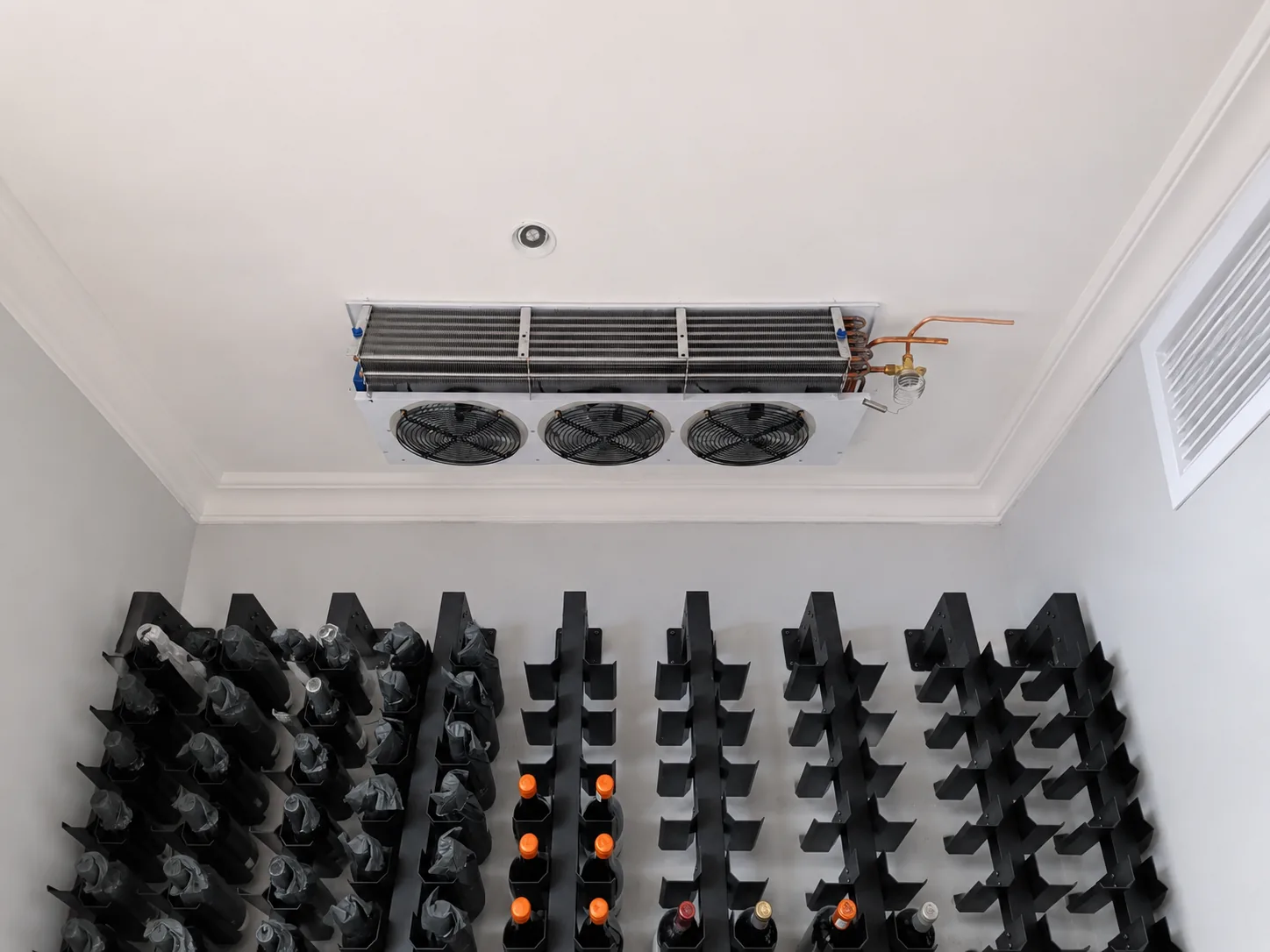 Completed custom wine cellar installation with bottle racks and cooling unit in Constantia