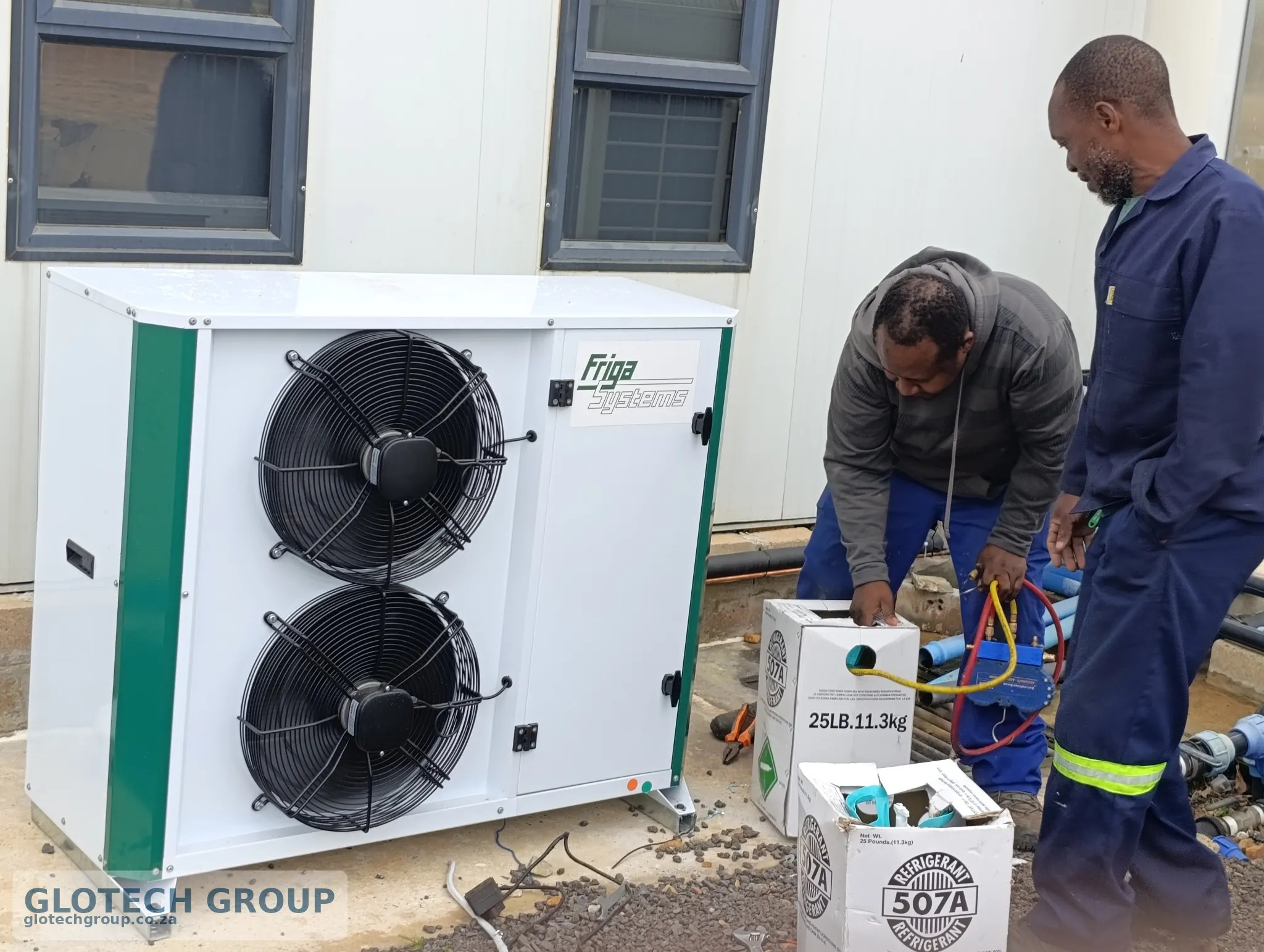 Technicians charging and testing the Fall Creek cold room refrigeration system.