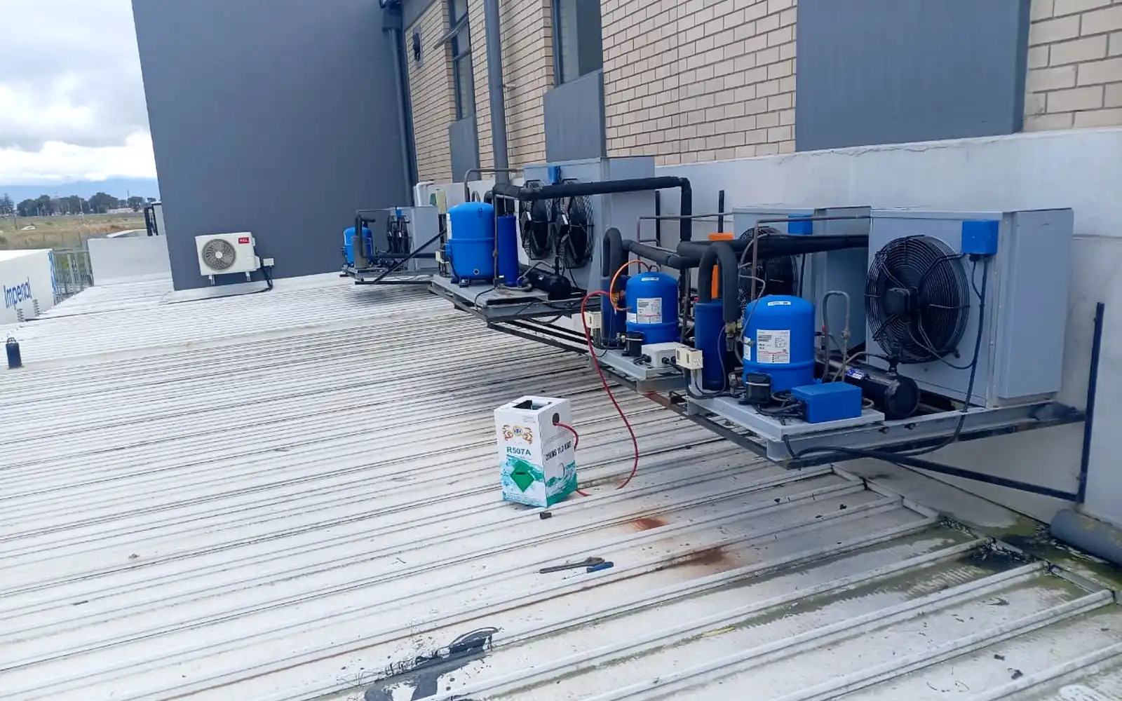 Multiple commercial refrigeration condensing units installed along a rooftop