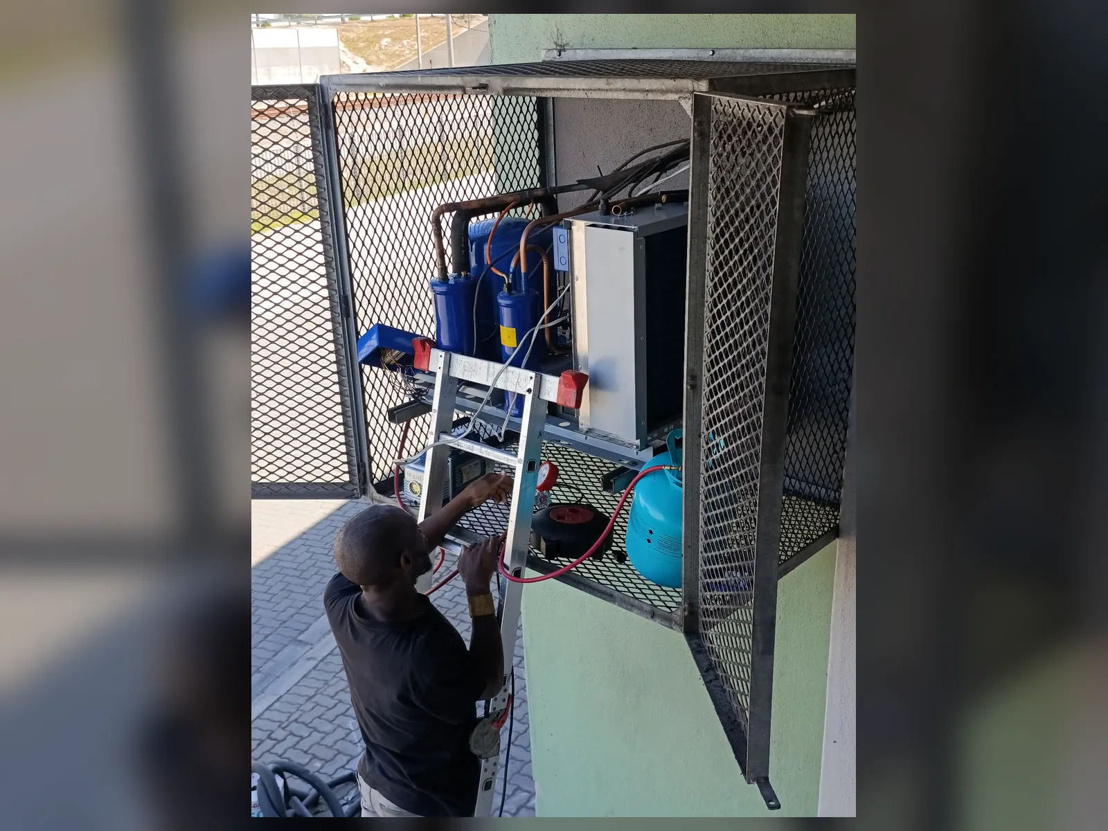 New commercial refrigeration condensing unit installed in protective cage