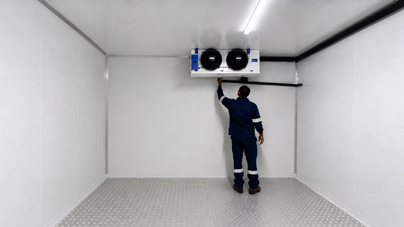 Technician inspecting the walk-in freezer refrigeration system at Milpark Meat Market