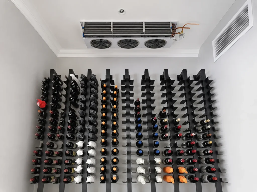 Ceiling-mounted wine cellar evaporator above bottle racks in Constantia